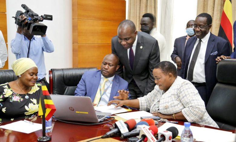 Prime Minister Robinah Nabbanja flanked by Henry Musasizi pressing the computer button to release PDM funds.