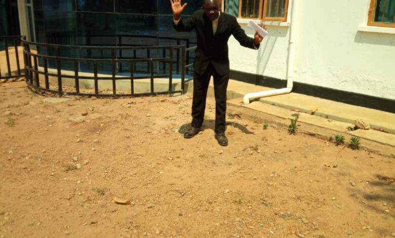 David Okot gesturing with utmost frustration as he left the district headquarters
