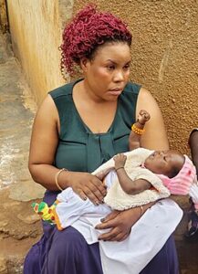 Mariam Nbatanzi holding a grandchild